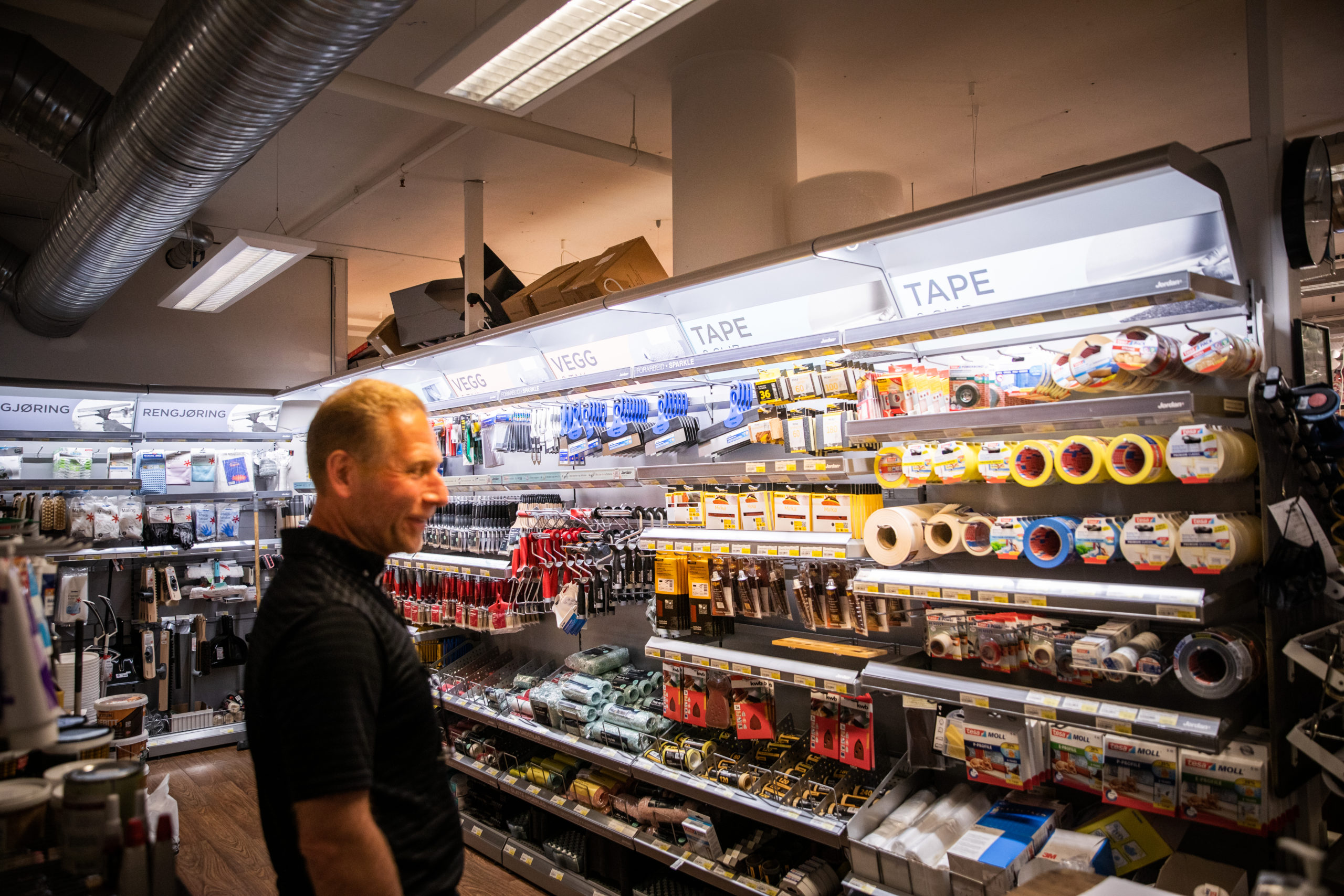 Steinar i butikken ved hyllene med jernvarer og teip